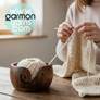 Cuenco para lana de madera de pino oscurecida - Garmon - Cuenco en primer plano con cake pequeño de lana color crema sobre una mesa, con señora tejiendo una prenda