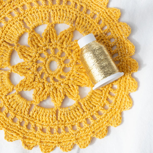 Proyecto tejido con lana amarilla y acompañado con hilo metalizado Drops Glitter en color Oro
