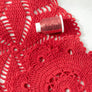 Proyecto tejido con lana roja y acompañado con hilo metalizado Drops Glitter en color Rojo